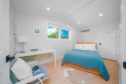 温哥华New laneway house near Airport, downtown, UBC的白色卧室配有床和书桌