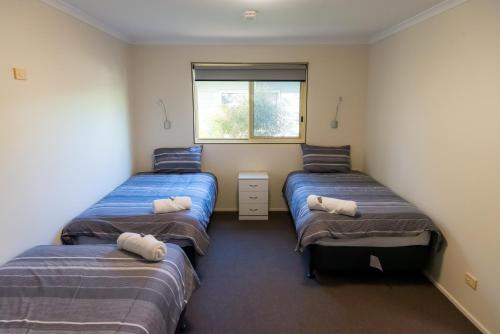 BelmontChandler Lodge and Cabins的带三张床和窗户的客房