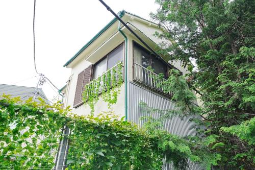 东京Family or Business Travel 20 percent OFF Free Ikebukuro Shuttle Garden Villa Up to 7 Guests的一座带阳台的建筑,上面有常春藤