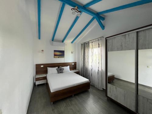 茹里洛夫卡Casa Lebăda的卧室设有白色的床和蓝色的天花板。