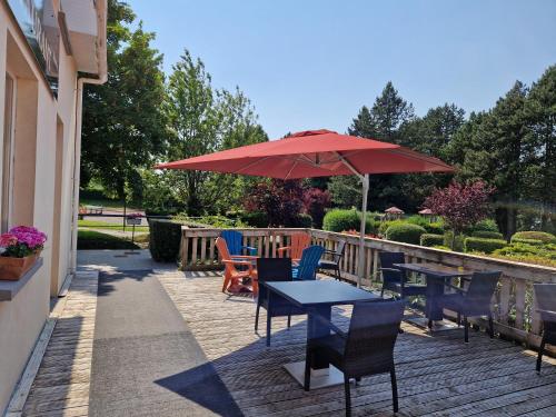 特诺亚姆巴勒酒店的一个带桌椅和红色遮阳伞的庭院