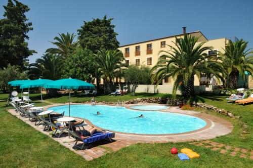 阿尔盖罗Alghero Resort Country Hotel & Spa的游泳池设有椅子,人们在游泳池里游泳