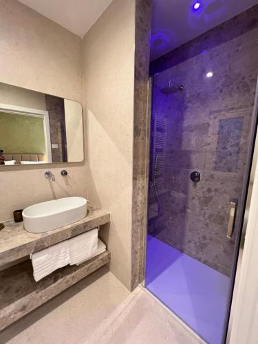SantʼEgidioCorteViva Boutique Cottage的一间带水槽和玻璃淋浴的浴室
