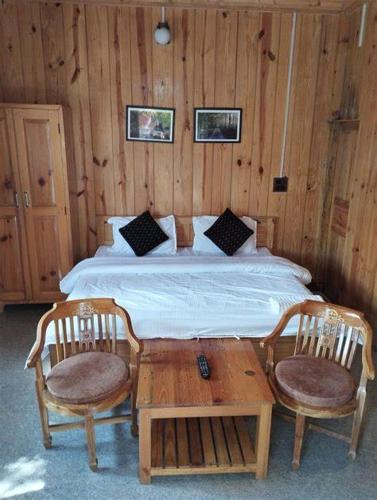 卢纳将军城Nena's Homestay的一间卧室配有一张带两把椅子和一张桌子的床。