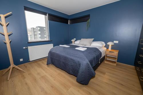 阿克雷里Family apartment hosted by LL的蓝色的卧室设有床和窗户