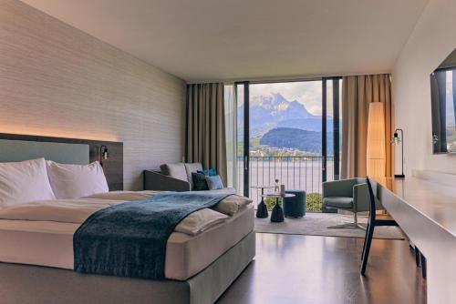 卢塞恩HERMITAGE Lake Lucerne - Beach Club & Lifestyle Hotel的山景卧室 - 带1张床