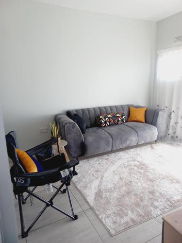 哈博罗内AGM Suites的客厅配有沙发和椅子