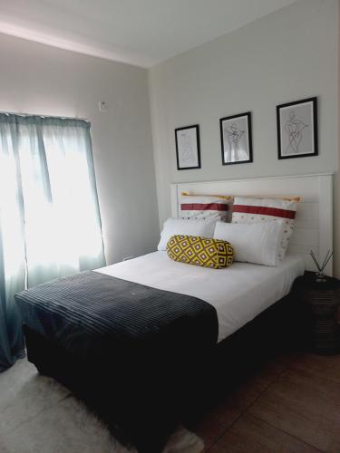 哈博罗内AGM Suites的一间卧室配有一张大床和两个枕头