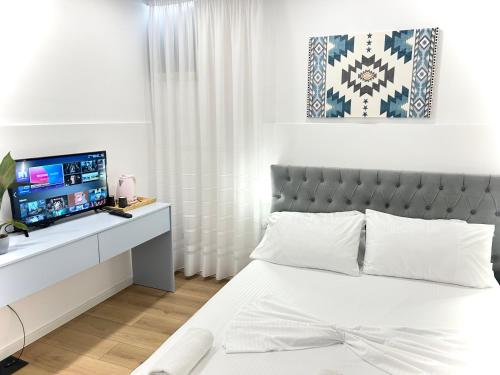 地拉那Tirana Square Hotel的一间白色卧室,配有床和电视