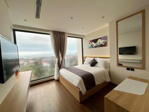 绥和市Kira Kira 's Apartment, Apec Mandala Phu Yen Condotel的酒店客房设有一张床和一个大窗户