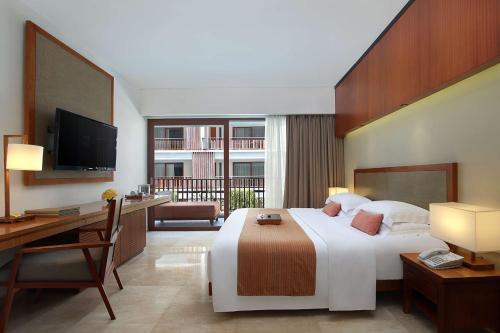 勒吉安The Magani Hotel and Spa的酒店客房配有一张床、一张书桌和一台电视。