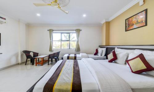 钦奈HOTEL SAlBALA INN - NEAR AIRPORT的酒店客房设有两张床和窗户。