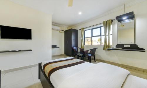 钦奈HOTEL SAlBALA INN - NEAR AIRPORT的一间酒店客房,配有一张床和一台电视