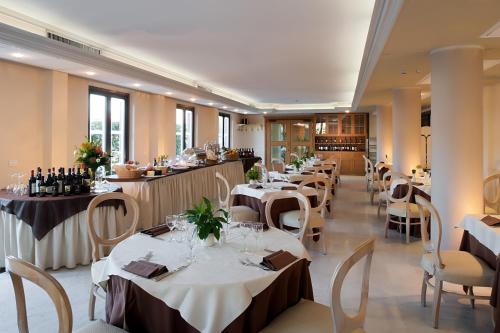 比萨布拉诺大酒店的餐厅配有桌椅和葡萄酒瓶