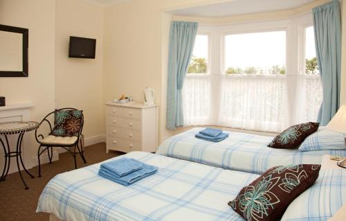 法利Binton Guest House的一间卧室设有两张床和窗户。