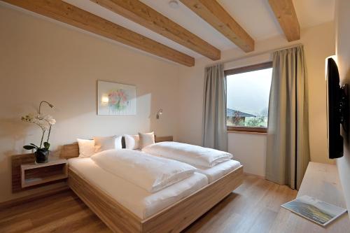 布利克森塔勒Resort Tirol Brixen am Sonnenplateau的卧室配有一张大白色床和窗户