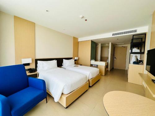 金兰市The Cam Ranh Beach Front的一间卧室配有一张大床和一张蓝色椅子