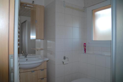 Les Geneveys-sur-CoffraneAppartment Aux Lilas的白色的浴室设有水槽和卫生间。