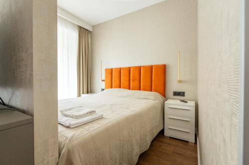 贝尔格莱德Kondina Suites的一间卧室配有一张带橙色床头板的大床