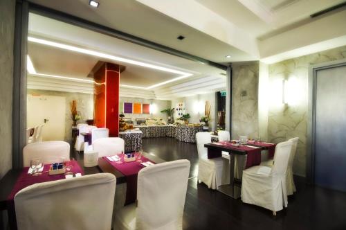 罗马阿里斯顿酒店的一间带桌子和白色椅子的用餐室以及一间餐厅