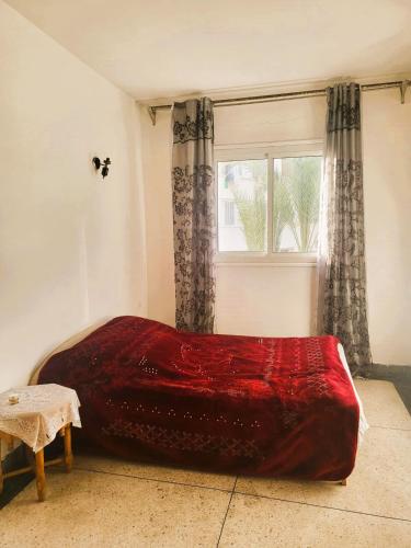 卡萨布兰卡Casablanca - City的窗户客房内的一张红色的床