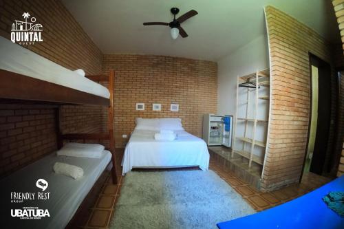 乌巴图巴HOSTEL QUINTAL GUEST Ubatuba - PG的一间卧室设有两张床和砖墙