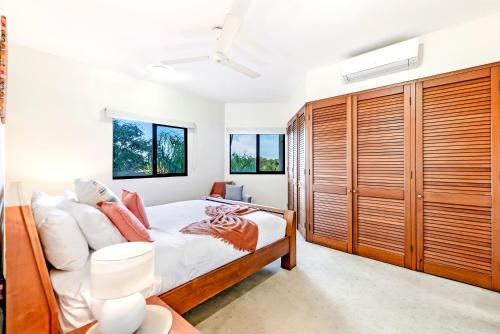达尔文Oceanview Tropical - A Top End Poolside Oasis的一间卧室配有一张床和木制橱柜
