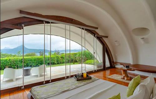 罗纳瓦拉Resort Amanzi的客房设有带沙发和椅子的大窗户。