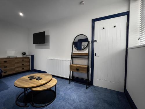 KillingworthNewly Refurbished 6 Person En-suite Apartment Tyne & Wear Newcastle Upon Tyne的一间设有桌子、镜子和门的房间