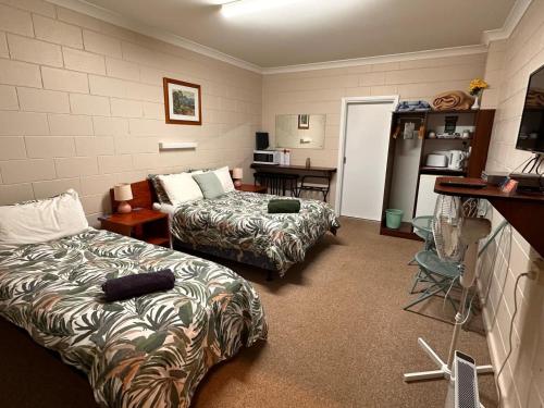 库马ALPINE COUNTRY MOTEL and METRO ROADHOUSE COOMA的酒店客房带两张床和厨房