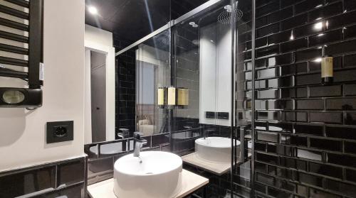 毕斯卡斯La Posada de Ruba的浴室设有两个水槽,铺有黑色瓷砖。
