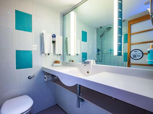 伦敦诺富特伦敦西区酒店的一间带水槽、卫生间和镜子的浴室