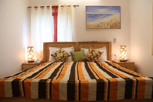 莫尔吉姆Villa Baywalk Goa的一间卧室配有带条纹被子的床和两盏灯