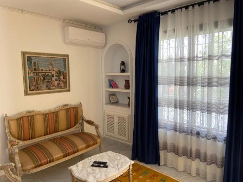 拉马萨Marsa - Sidi Bousaid Lovely Authentic Apartment的客厅配有椅子和窗户