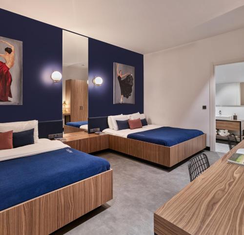 里加Kepler Club Riga Airport Hotel - Landside的蓝色墙壁客房的两张床