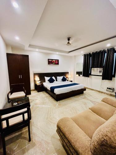 新德里Hotel The Paradise In - Near Karol Bagh Metro Station的一间大卧室,配有一张床和一张沙发