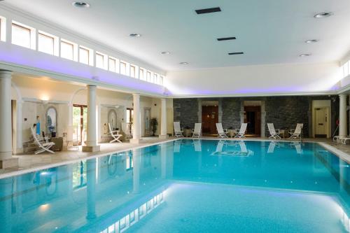 兰盖夫尼Tre-Ysgawen Hall & Spa的酒店的大型游泳池配有椅子