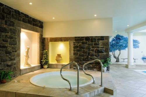 兰盖夫尼Tre-Ysgawen Hall & Spa的一间石墙内大浴室,配有浴缸