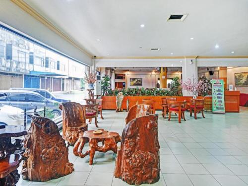 丹戎槟榔OYO 1178 PLAZA HOTEL TANJUNG PINANG的大楼内带桌椅的餐厅
