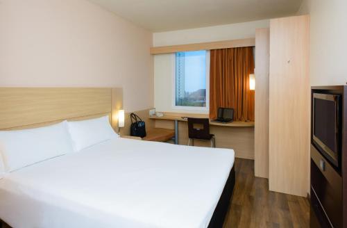 萨尔瓦多萨尔瓦多红河宜必思酒店的酒店客房设有一张白色大床和一张书桌