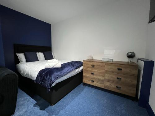 KillingworthNewly Refurbished 6 Person En-suite Apartment Tyne & Wear Newcastle Upon Tyne的一间卧室配有一张床和一个木制梳妆台