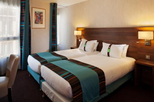 巴黎巴黎蒙马特智选假日酒店的一间位于酒店客房内的带大床的卧室