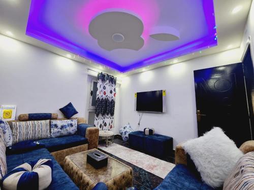 亚历山大شقة فندقية مكيفة ميامي ع البحر مباشرةً的一间拥有紫色天花板的客厅