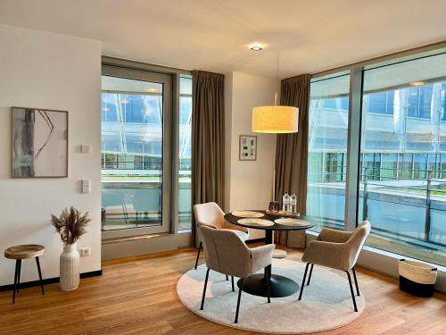 汉堡Come2Stay Hafencity - Marco Polo Tower的客厅配有桌椅和大窗户