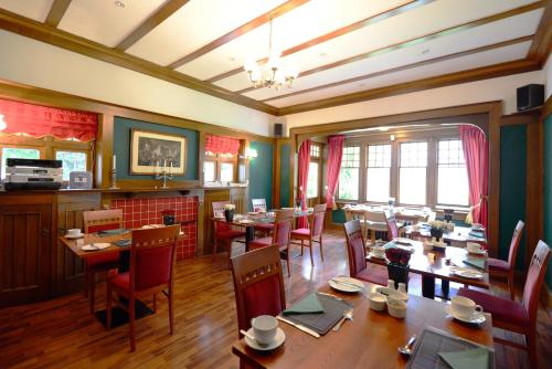 邓弗里斯利文德尔酒店的用餐室配有木桌和椅子