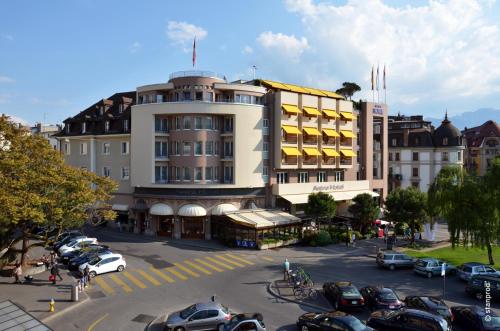 沃韦Astra Vevey Hotel & Restaurant的停车场内停放汽车的大型建筑