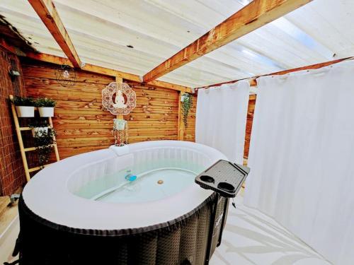 莫尔莱Ty Koeur - Gîte de charme的木墙客房内的按摩浴缸