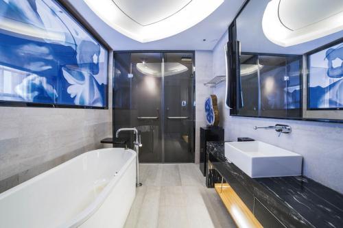 南京南京苏宁索菲特银河大酒店的浴室配有白色浴缸和水槽