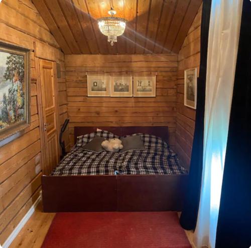 萨翁林纳Log house in Savonlinna的木房的一张床位,上面有泰迪熊