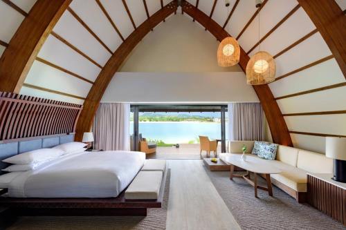 Momi斐济莫米湾万豪度假酒店的一间卧室配有一张床、一张沙发和一张桌子